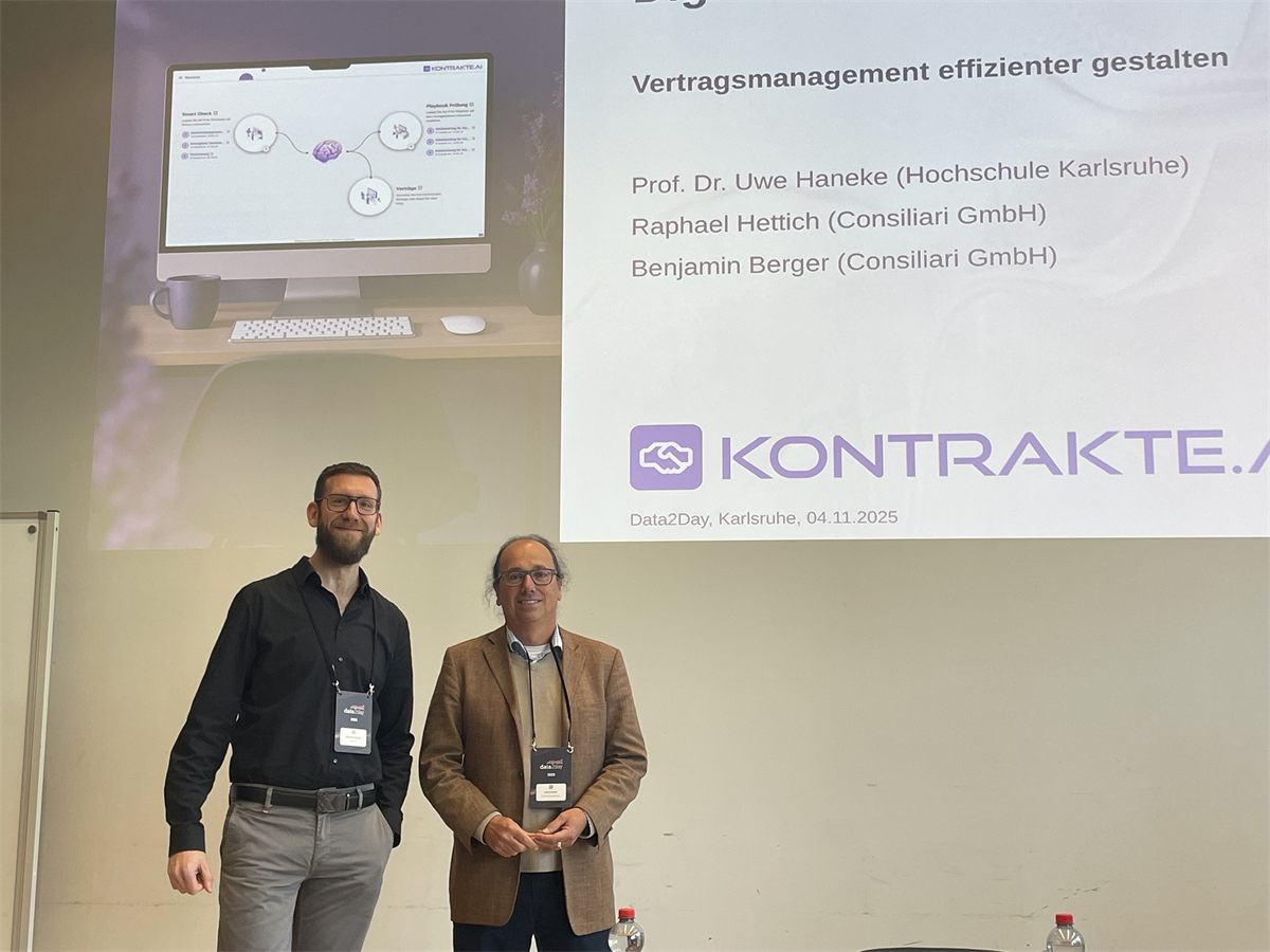 Benjamin Berger und Prof. Dr. Uwe Haneke vor der Titelfolie ihres Vortrags „Vertragsmanagement effizienter gestalten“ auf der data2day 2025 in Karlsruhe